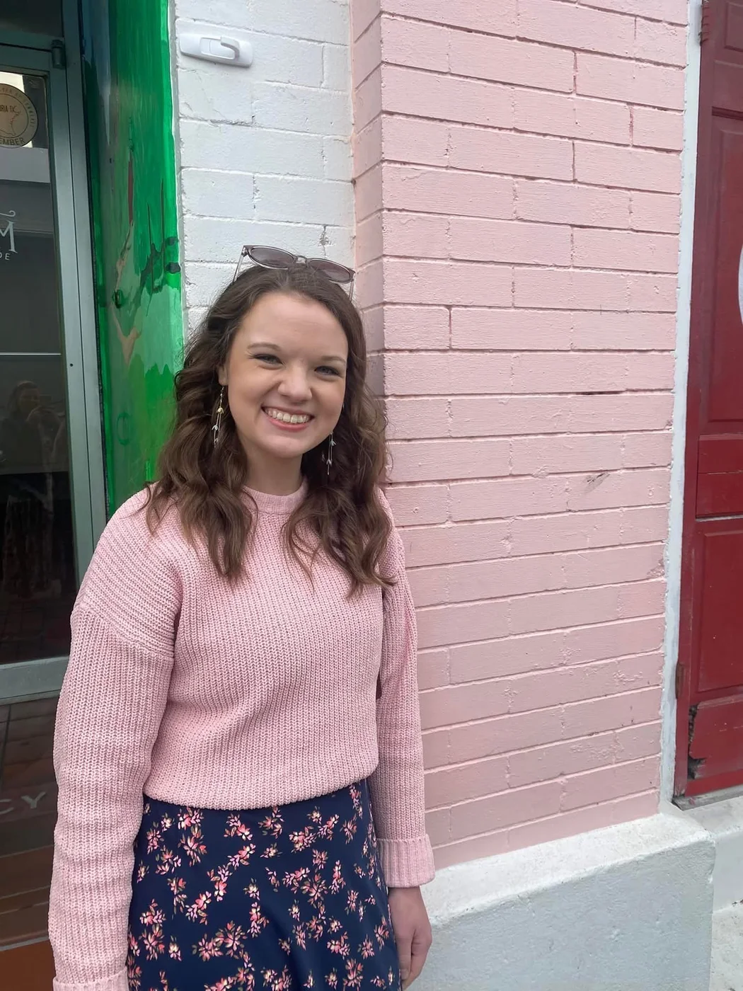 Mikayla Rich, wedding coordinator, smiling in a pink sweater